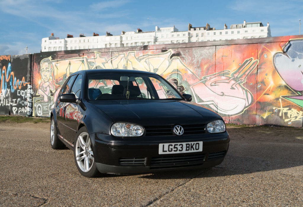 Black Volkswagen Golf Mk4 front 3/4 shot in front of graffiti