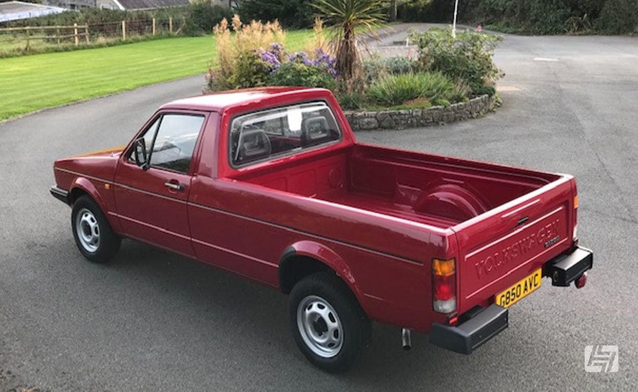 Original Volkswagen Caddy Mk1 in burgundy red  showing off perfect load bed and black corner bumpers