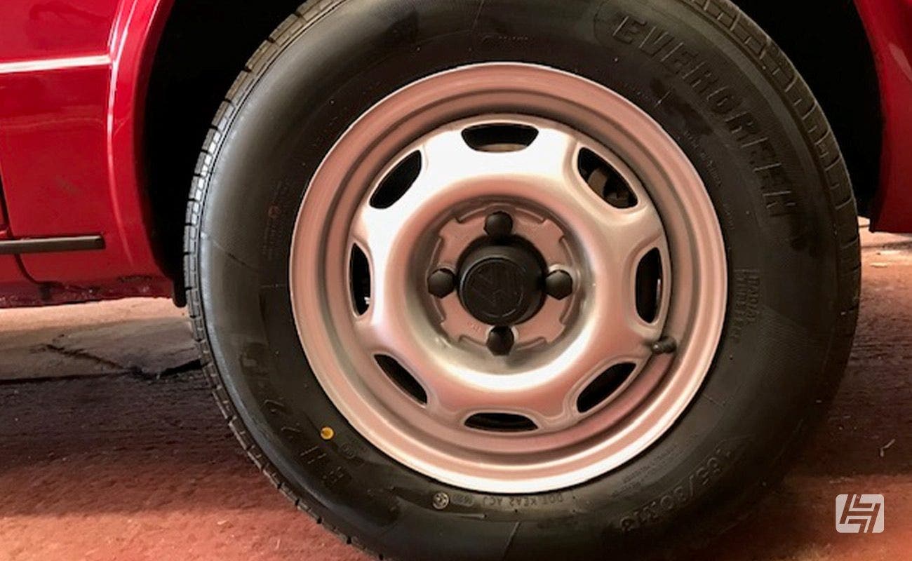 Original silver steel wheels with black centre cap and wheel nut covers on VW Caddy Mk1 