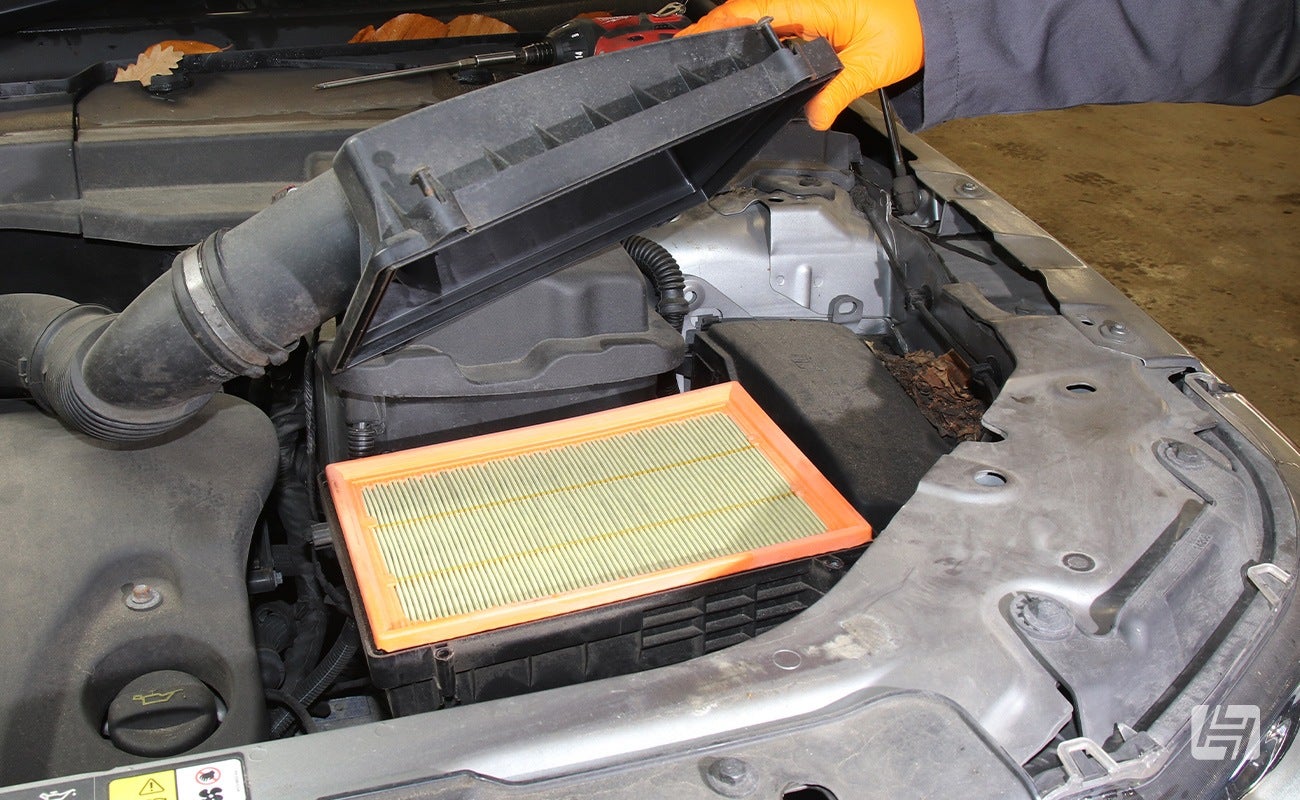 Mechanic lifts up the lid on the Land Rover Freelander 2 airbox