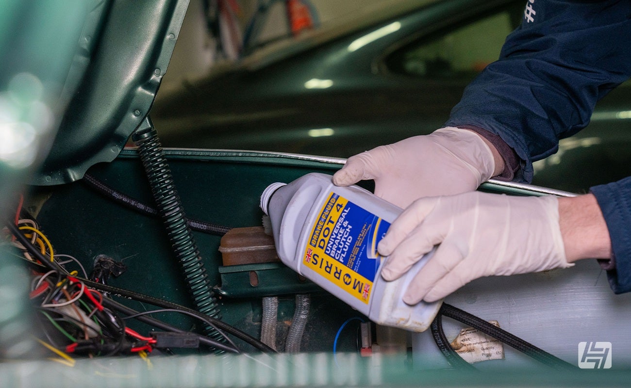 Pouring brake fluid into reservoir on VW Beetle