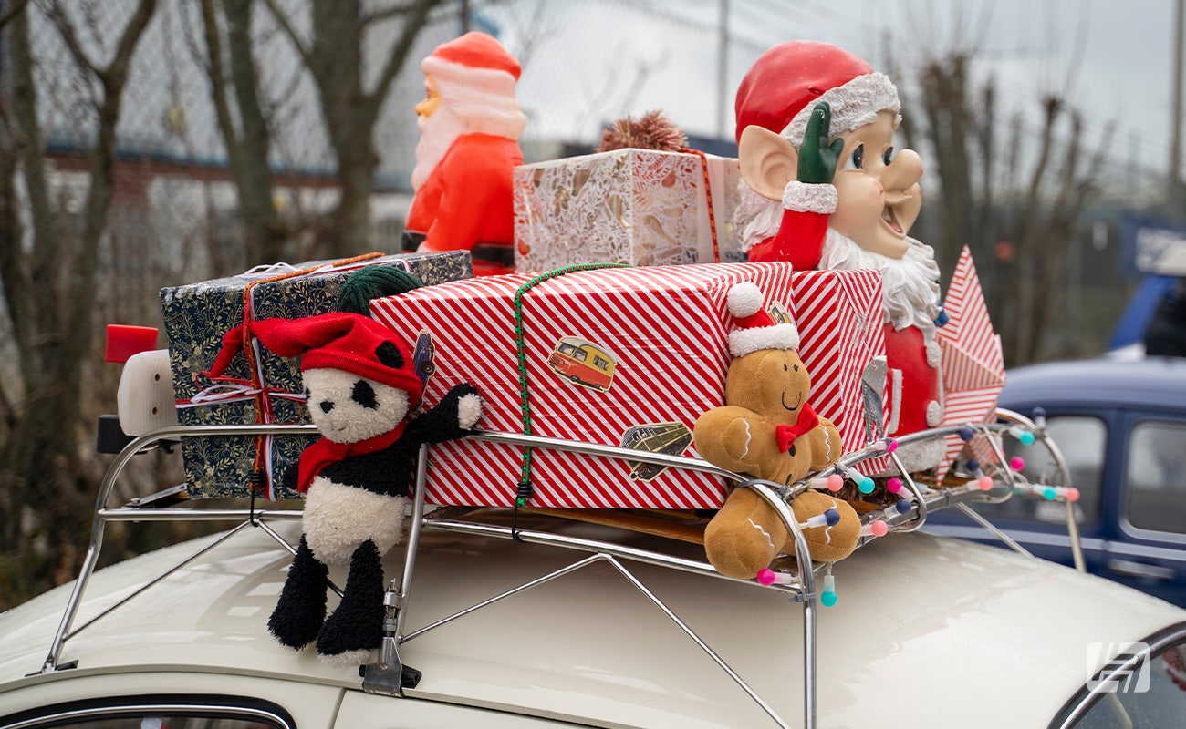 White VW Beetle with presents and toys on roof rack