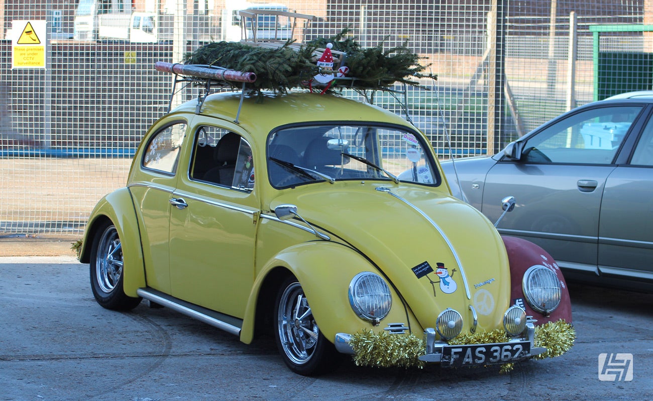 Yellow VW Beetle with Christmas tree on the roof rack