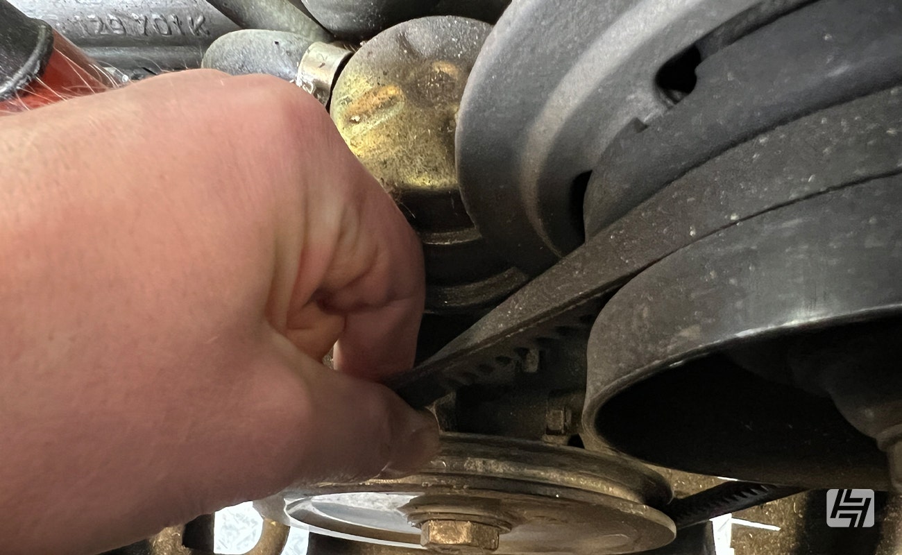 twisting a vehicle fan belt to check for tightness