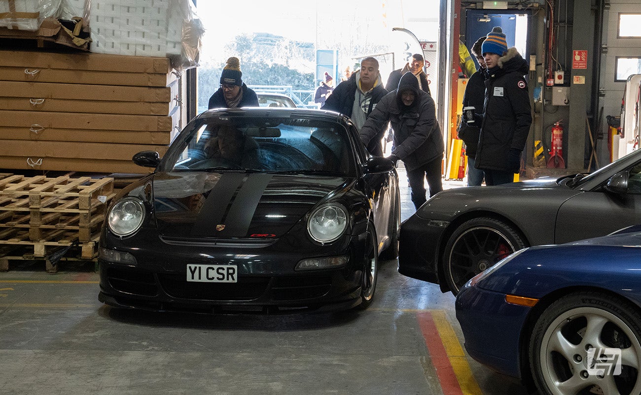 Black Porsche 997 CSR pushed inside at Heritage Parts Centre 9Werks warehouse meet